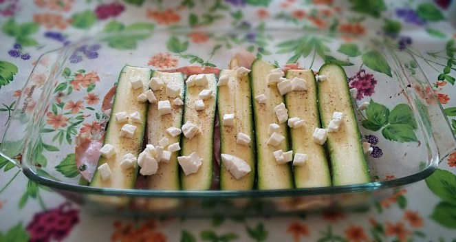 La pirofila viene riempita a strati, disponendo le zucchine e poi le fette di mortadella e i pezzetti di mozzarella.