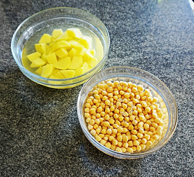 I ceci e le patate tagliate a mirepoix posti in ammollo in acqua.